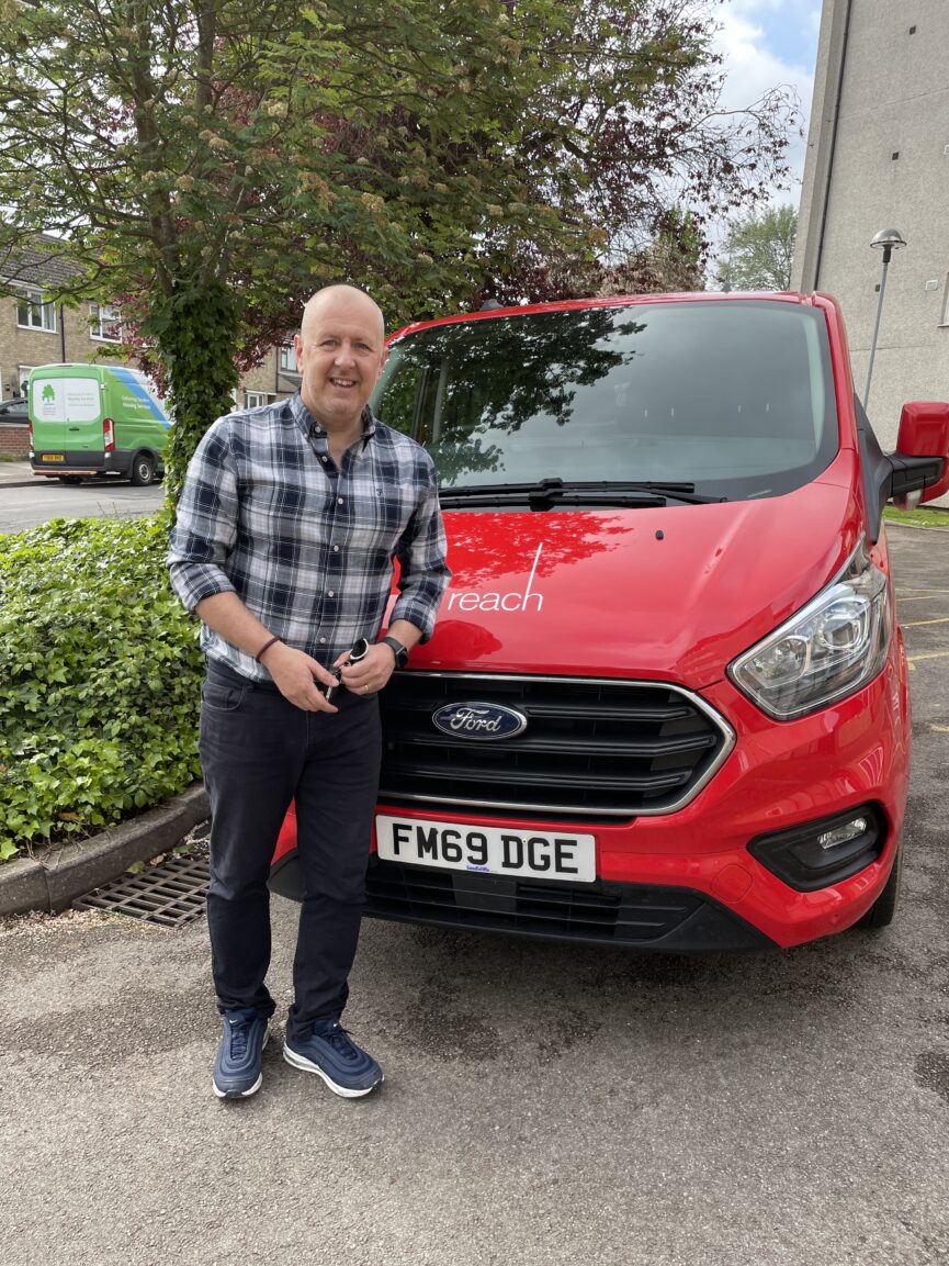 Photo of Wayne leaning against the Reach van